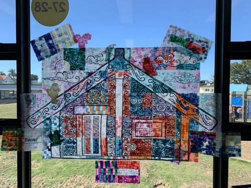 Colourful window display of a whare/house
